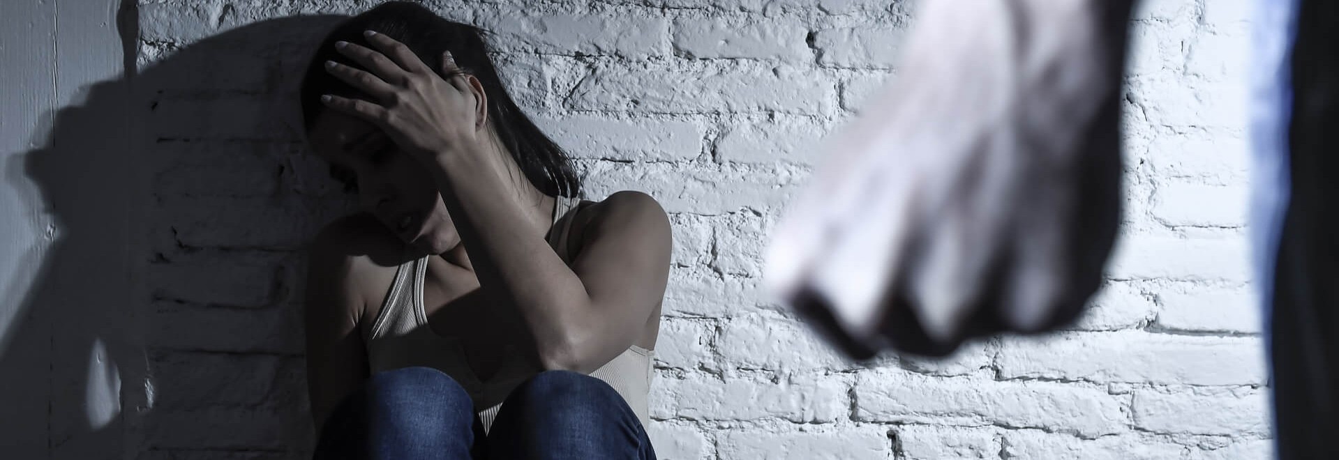 woman hiding her head from the man who wants to punch her