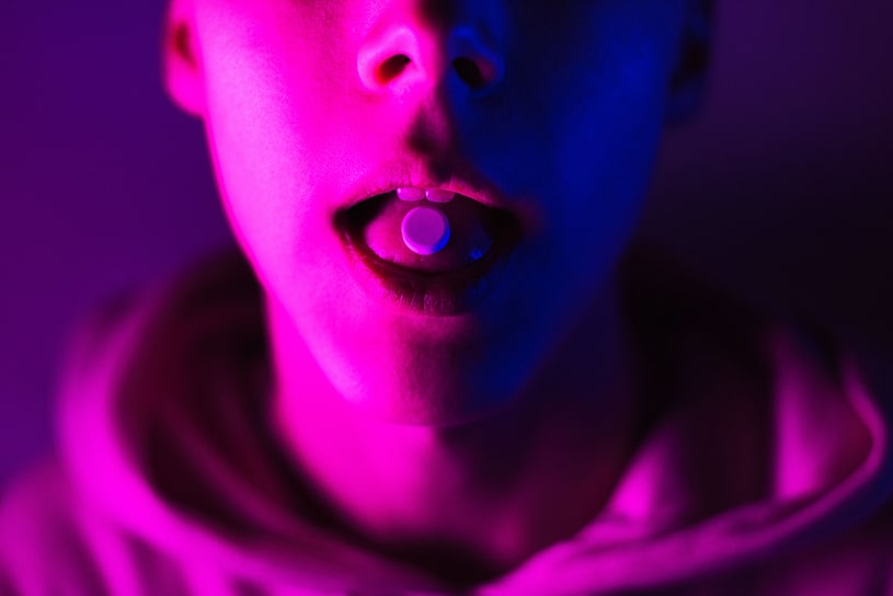 The guy has an LSD pill on his tongue.