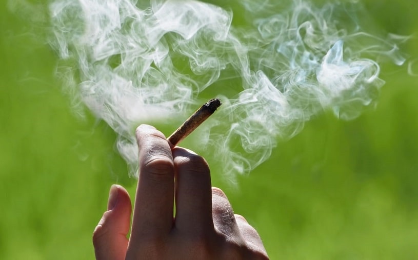 Person smoking marijuana joint.