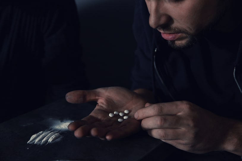 The guy goes through drugs in a dark room.