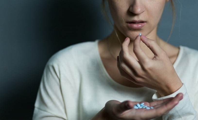 Depressed girl takes a lot of Xanax pills.