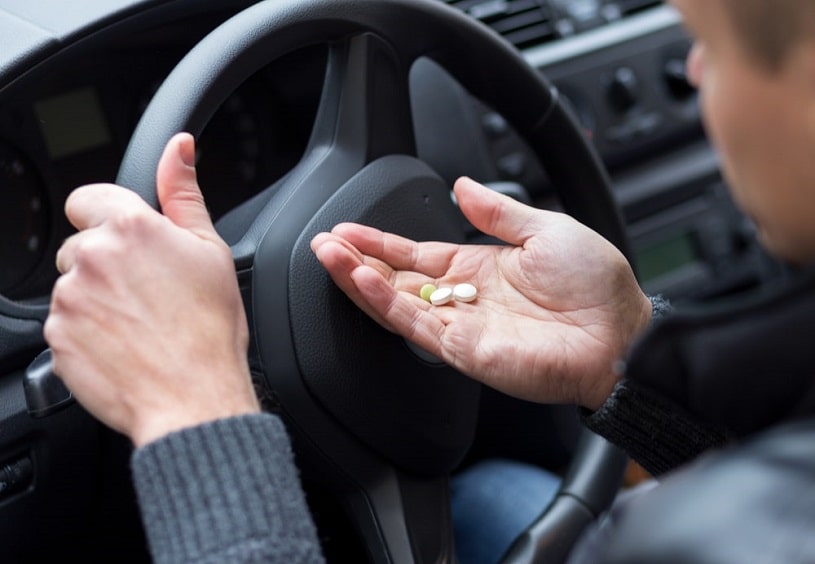Man is taking Xanax in the car.
