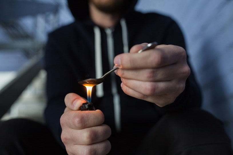 Crack addict with a lighter and spoon.