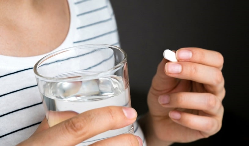 Woman taking a Xanax pill.