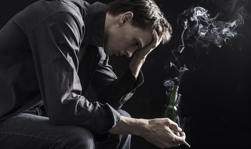 Depressed man smoking a cigarette.