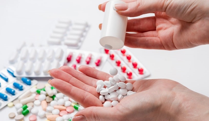 Woman pours pills into her hand.