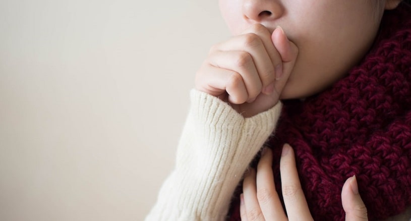Young woman suffering from cough.