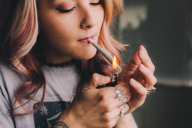The girl lights up a joint.