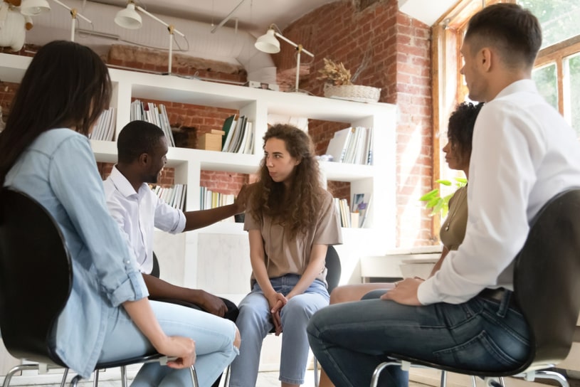 The girl in the support group sits in the center.