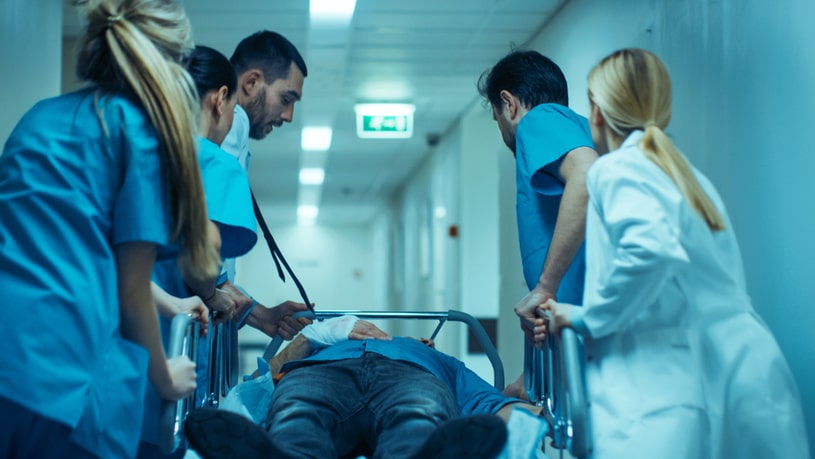 The patient and the doctors who carry him in a mobile bed.