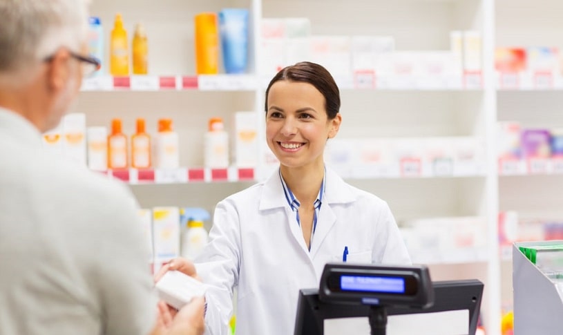 Pharmacist giving pills to a patient.