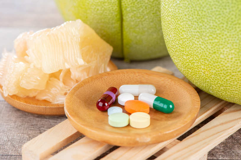 Benadryl pills lie on the table with grapefruit.