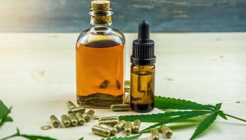 CBD oil in the bottle and marijuana leaves.