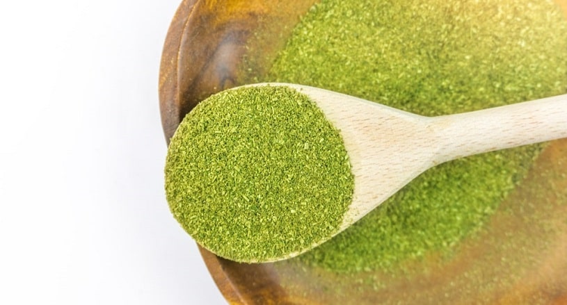 Kratom powder in a wooden spoon.