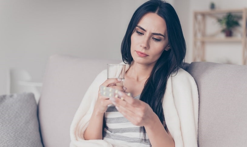 Woman reading the indication on Prozac pills.