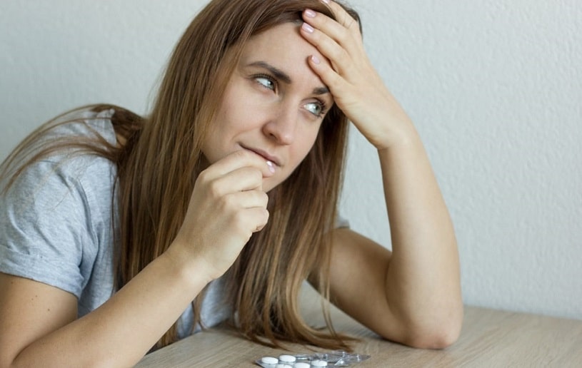 Sick ill depressed woman taking a pill.