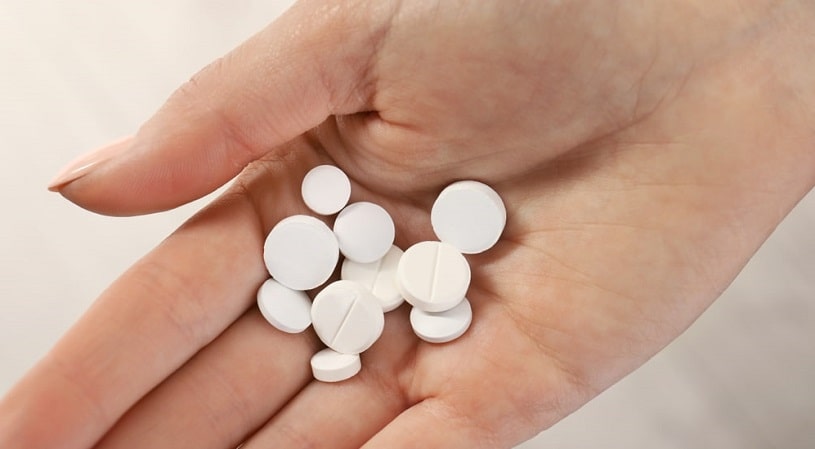 Woman hand holding many Valium pills.