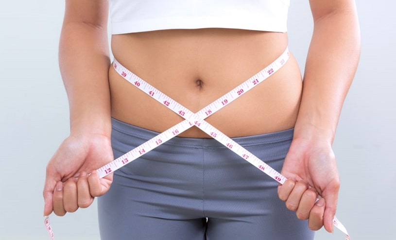 Woman measuring her waist.