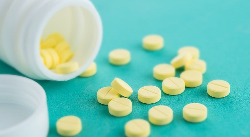 Yellow Valium pills spilled from the bottle.