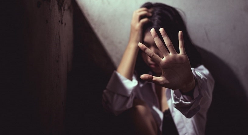 Depressed girl next to the wall feeling sad.
