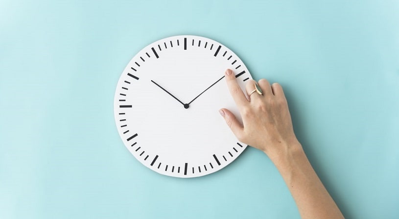 Clock and a hand on the blue background.