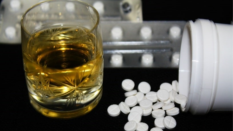 Pills and a glass of alcohol.