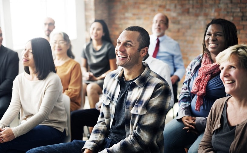 Support group meeting, people sitting and smiling.