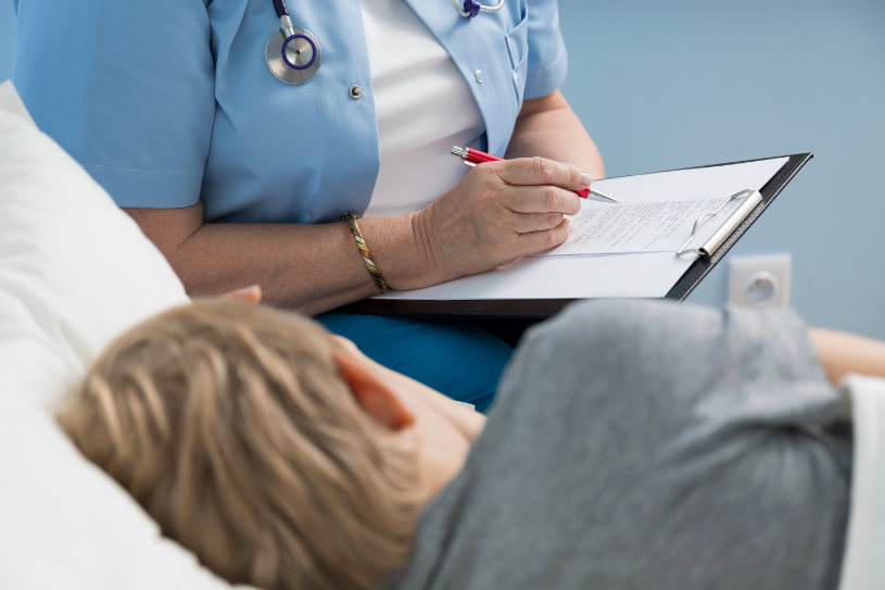 A medical worker consults a patient lying in bed regarding Sonata abuse treatment options.