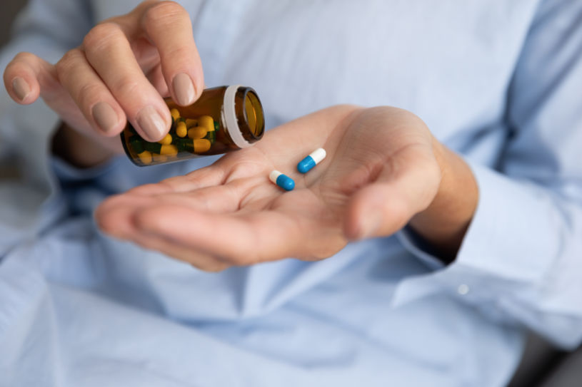 A woman holds Midazolam pills in her hand.