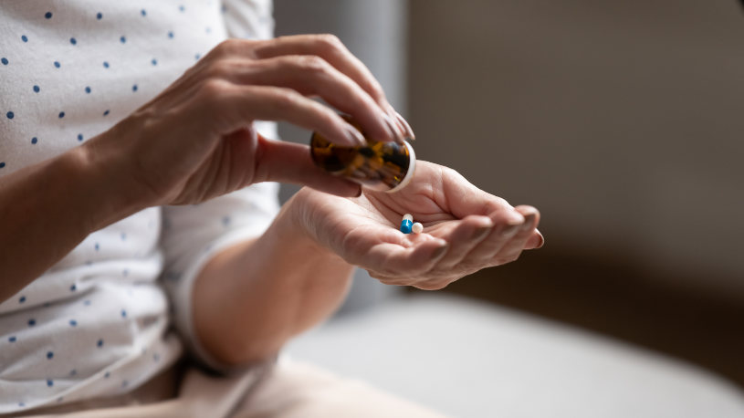A woman takes Demerol pills in her hand.