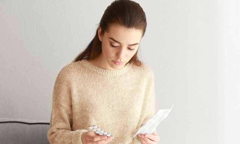 Woman reading Accutane warnings and indications.