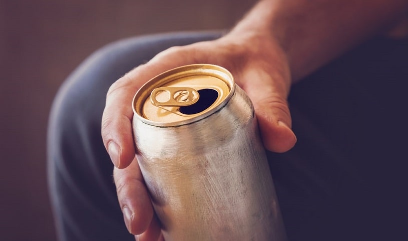 Man holding an energy drink in hand.