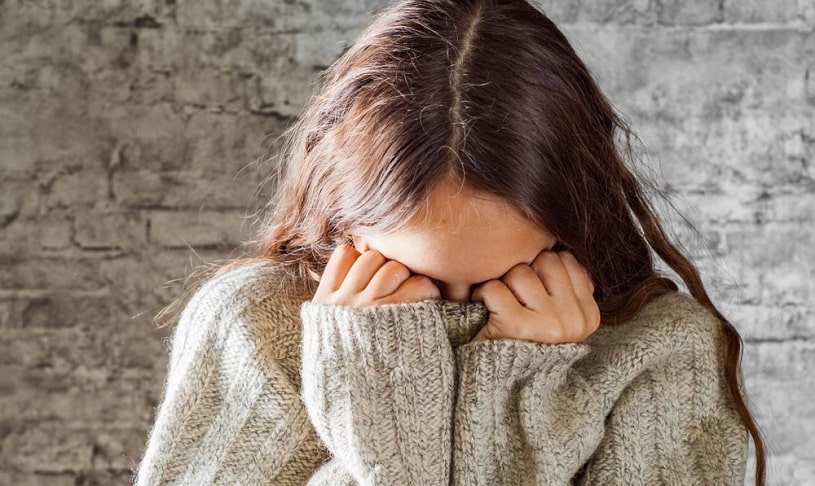 Woman covering her face.