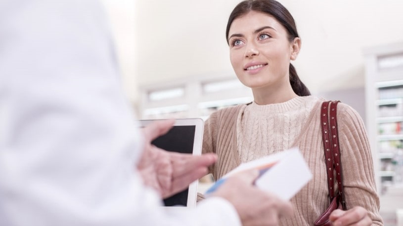 Pharmacist telling a woman about Lortab side effects and precautions.