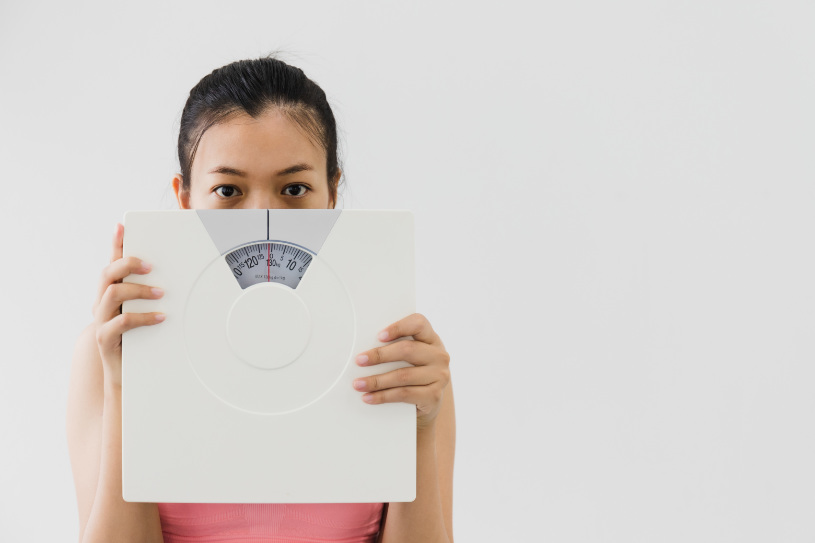 A disappointed woman is holding scales.