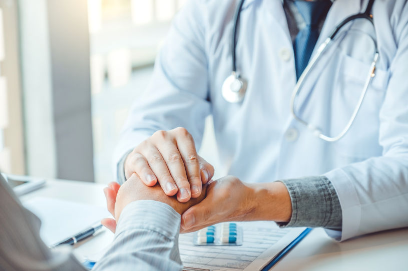 Doctor holding hands for comforting and care patient.