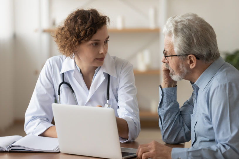 Young female professional doctor physician consulting old male patient.