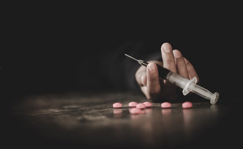 A-crazed-drug-addict-reaches-for-another-dose-of-the-drug-in-the-syringe.