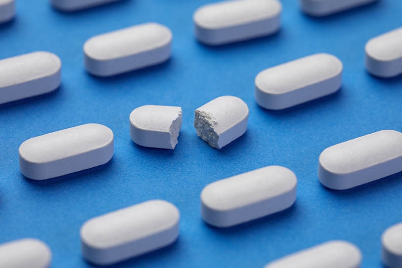 A lot of pills on the blue background.