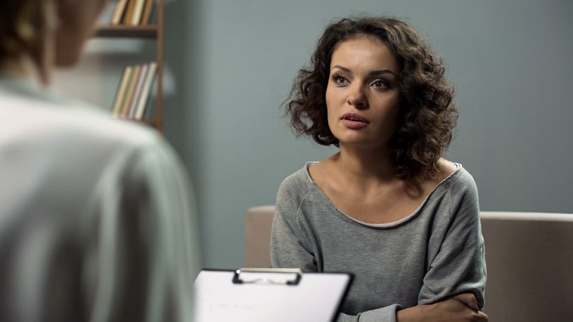 Woman discussing her addiction with a doctor.