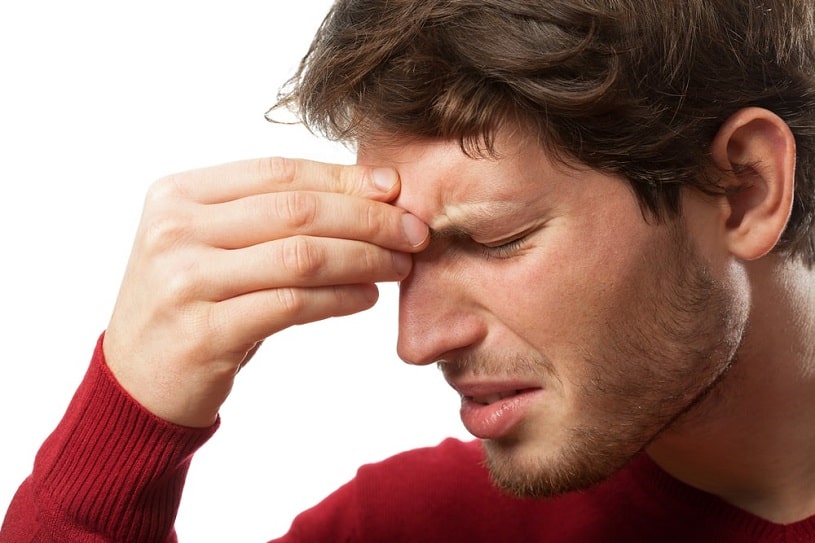 Man holding his forehead because of a headache.