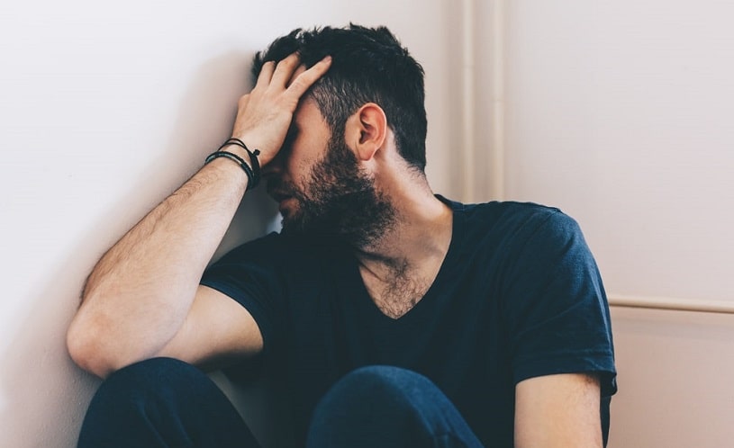 Sad depressed man sitting in the corner.