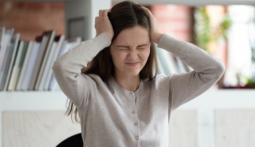 Girl holding her head, stressed because of Librium withdrawal.