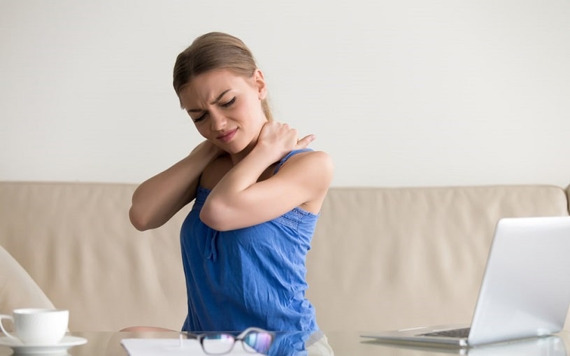 Woman feeling neck pain massaging her back.