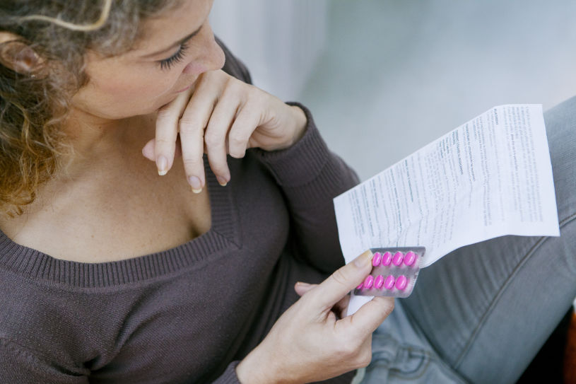 A woman reads an article about Vyvanse half-life.