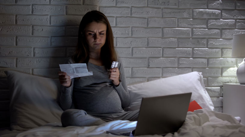 A pregnant woman reads about Phenobarbital side effects.