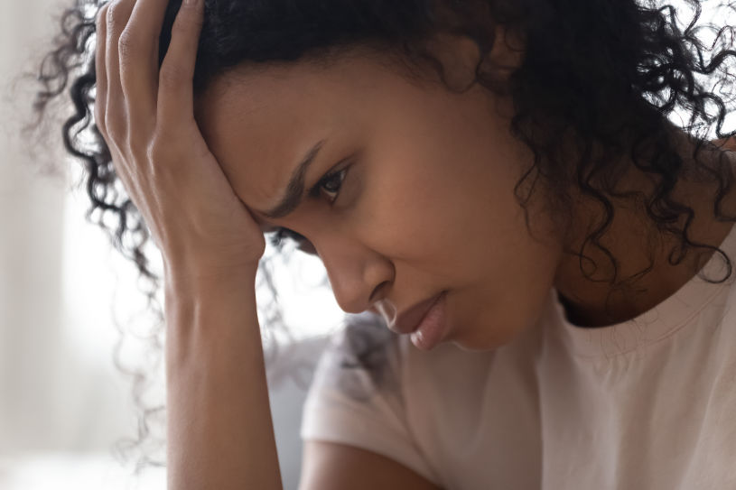 A woman experiences headache because of drug abuse.