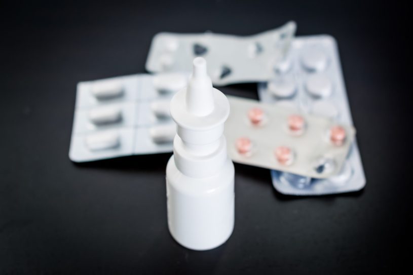 Nasal spray and pills on the black table