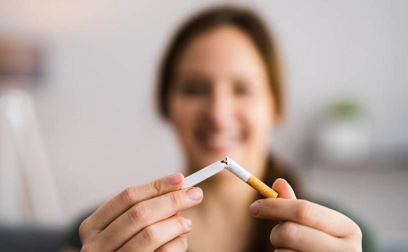Woman breaking a cigarette, decides to quit smoking.