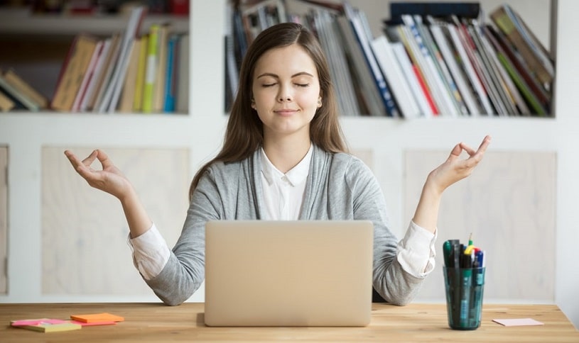 Woman practicing meditation at work to calm down.